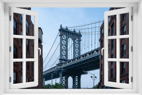 Fototapeta Naklejka Na Ścianę Okno 3D - Closeup of Manhattan Bridge between two brown Buildings
