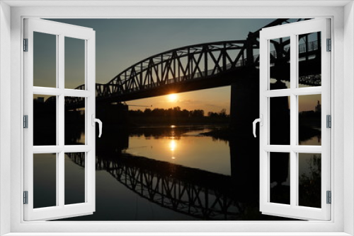 Fototapeta Naklejka Na Ścianę Okno 3D - The reflection of the old bridge on the river,The silhouette of the old bridge at sunrise or sunset in the countryside