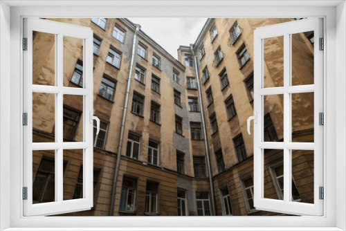 Fototapeta Naklejka Na Ścianę Okno 3D - The courtyard of an old apartment building in St. Petersburg with yellow shabby walls