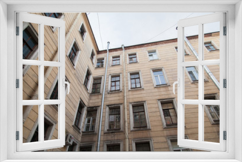 Fototapeta Naklejka Na Ścianę Okno 3D - The courtyard of an old apartment building in St. Petersburg with yellow shabby walls