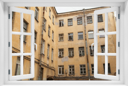 Fototapeta Naklejka Na Ścianę Okno 3D - The courtyard of an old apartment building in St. Petersburg with yellow shabby walls