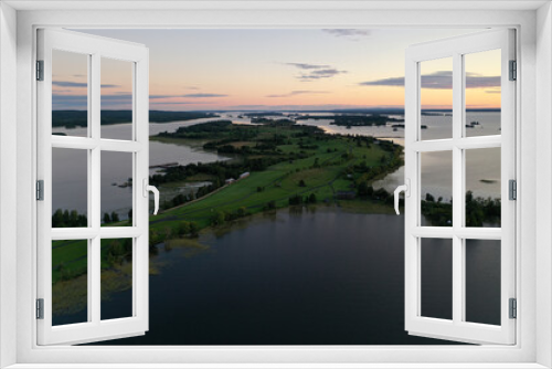 Fototapeta Naklejka Na Ścianę Okno 3D - panoramic view of the lake with many islands on one of them there is an ancient temple made of wood at sunset filmed from a drone