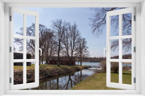 Fototapeta Naklejka Na Ścianę Okno 3D - The view of bare trees and lake in a sunny day near Gripsholm Castle in spring, Mariefred, Sweden.