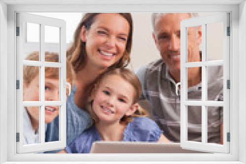 Portrait of a family sitting on a couch using a laptop