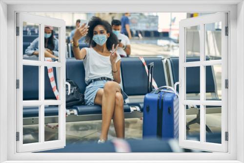 Cute African young female taking selfie on her mobile for friends