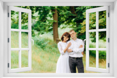 Sensual newlyweds posing in a green garden.