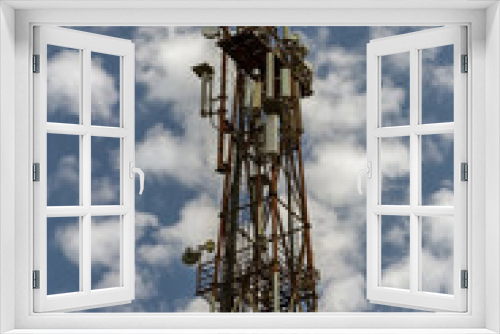 Fototapeta Naklejka Na Ścianę Okno 3D - Telecommunication equipment on a blue sky background. Directional antenna for mobile phones. The concept of wireless communication. Tower with a communication repeater antenna. Repeater
