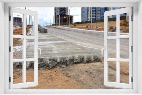 Fototapeta Naklejka Na Ścianę Okno 3D - Road works activity at construction site. Construction and development projects on roads in city. Road concreting. Asphalt pavement is layered over concrete pavement