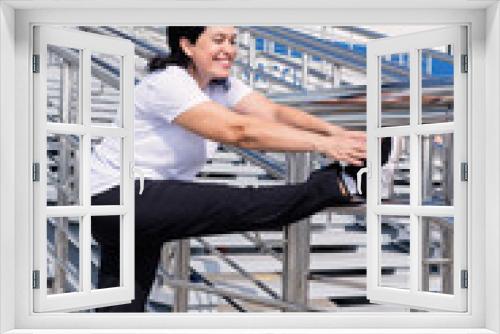 Smiling senior woman doing stretching outdoors on urban background