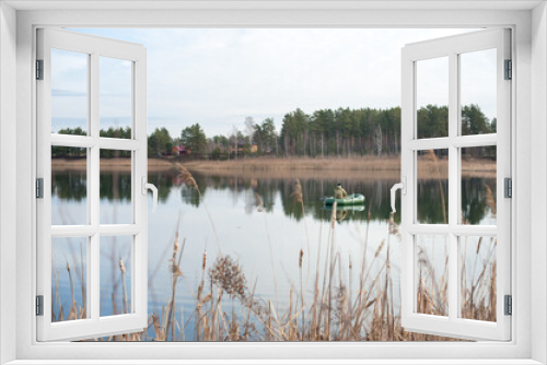 Fototapeta Naklejka Na Ścianę Okno 3D - general view of a fisherman sitting with his back in a boat on a lake