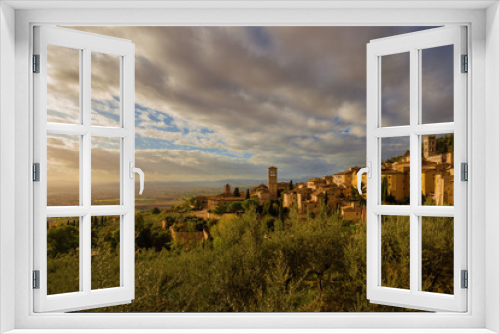 Fototapeta Naklejka Na Ścianę Okno 3D - View of the Assisi historic center ancient buildings and nearby countryside at sunset with beautiful clouds