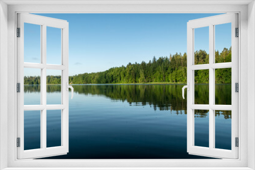 Fototapeta Naklejka Na Ścianę Okno 3D - mirror image on the lake, green forest by the lake in reflection in the blue water, beauty in nature