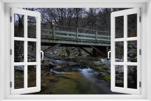 Fototapeta Naklejka Na Ścianę Okno 3D - Iron bridge over the stream in the forest, Rascafría, Madrid, Spain