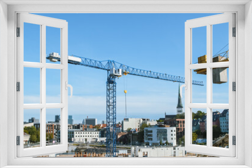 Fototapeta Naklejka Na Ścianę Okno 3D - Aerial Shot of a New Constructions Development Site with High Tower Cranes Building Real Estate. Heavy Machinery and Construction Workers are Employed. City Houses in the Background.