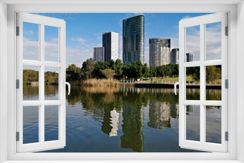 Fototapeta Naklejka Na Ścianę Okno 3D - Beautiful view of a lake with reflections of luxury high-rise building, blue sky, clouds, and trees on water, lake Pavillion,  Sydney Olympic park, Sydney, New South Wales, Australia
