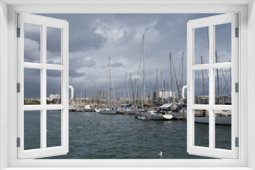 BARCELONA, SPAIN on SEPTEMBER 2019: View to yachts in port of european city at Catalonia district, cloudy sky in cold summer day.