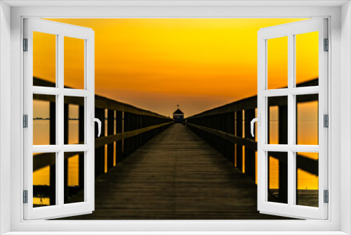 Fototapeta Naklejka Na Ścianę Okno 3D - Wooden pier by the ocean at sunset, view down along the boardwalk.