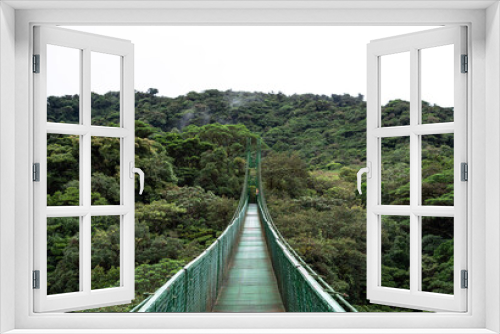 Fototapeta Naklejka Na Ścianę Okno 3D - Monteverde Cloud Forest hanging bridge, Costa Rica, cloudy jungle empty, suspension chain bridge over and through the moist wet Rainforest