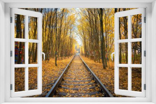 Fototapeta Naklejka Na Ścianę Okno 3D - Beautiful railroad in autumn forest at sunset. Industrial landscape with railway station, trees with colorful orange and yellow leaves in fall. Old railroad in Tunnel of Love in Ukraine