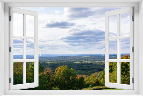 Fototapeta Naklejka Na Ścianę Okno 3D - View of landscape with green, orange, and golden trees and valley