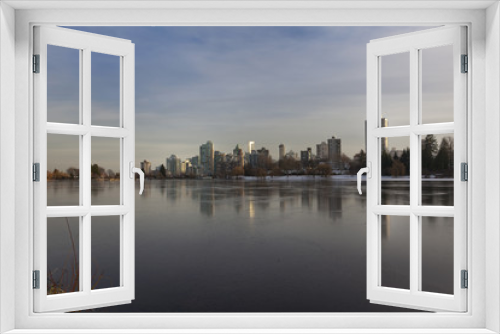 Fototapeta Naklejka Na Ścianę Okno 3D - Vancouver, BC skyline reflects over frozen lost lagoon