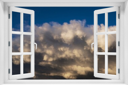 This image shows large rain clouds threatening a bright blue sky.