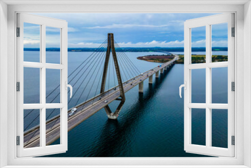Fototapeta Naklejka Na Ścianę Okno 3D - Large highway bridge spanning over a bay, with cars and trucks driving. Aerial view.