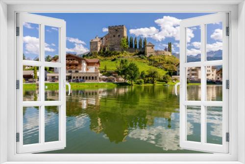 Laudegg Castle is reflected in the lake below on a beautiful sunny day, Ladis, Serfaus, Tyrol, Austria