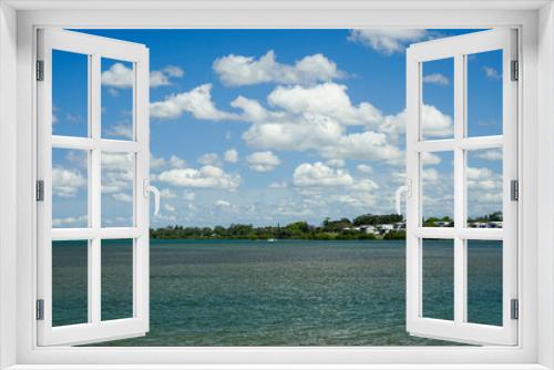Fototapeta Naklejka Na Ścianę Okno 3D - Clouds over the bay. View across the water from Victoria Point to houses and trees along the waterfront at Redland Bay, Queensland, Australia. 