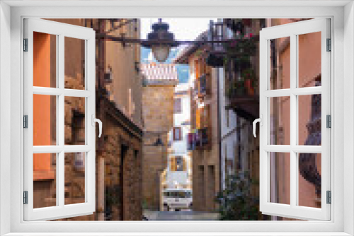 Fototapeta Naklejka Na Ścianę Okno 3D - Narrow street in old town, Europe. Downtown in mountains, Spain. Facade of ancient houses. Historical cityscape. Empty town. Quarantine pause in Spain. Residential district with no people. Old centre.