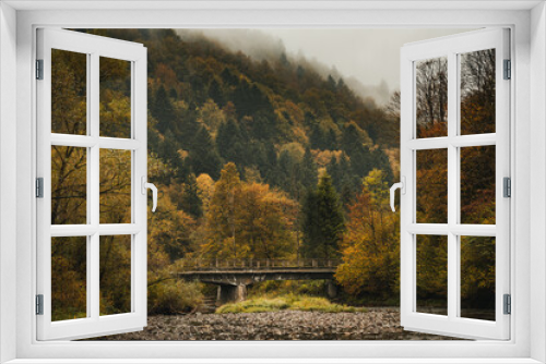 Fototapeta Naklejka Na Ścianę Okno 3D - Old Bridge over Mountain River in Bieszczady at Autumn Season. Moody Toned Landscape