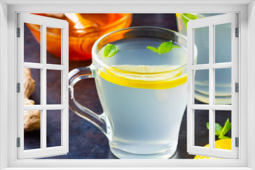 Fototapeta Naklejka Na Ścianę Okno 3D - Ginger tea with lemon on a dark background. Two cups of ginger tea and ingredients for its preparation