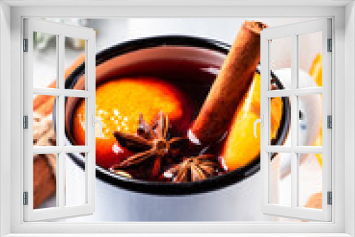 Fototapeta Naklejka Na Ścianę Okno 3D - Mulled wine in white metal mugs with cinnamon, spices and orange on gray background, traditional drink on winter holiday. Copy space