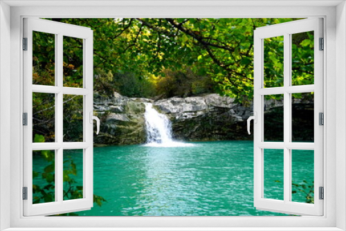 Fototapeta Naklejka Na Ścianę Okno 3D - Waterfall in the woods flowing towards a turquoise lake