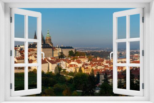 Fototapeta Naklejka Na Ścianę Okno 3D - the old St. Vitus Cathedral and Prague Castle and the nearby ones with trees and grass in autumn   and a sky without clouds at sunset in the center of city