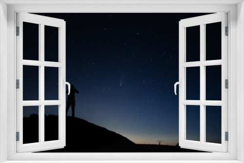 Fototapeta Naklejka Na Ścianę Okno 3D - Jeune Homme Observe Regarde Comète Ciel Étoile Sur Une Coline Un Soir d’été Constellations Heure Bleue Normandie
