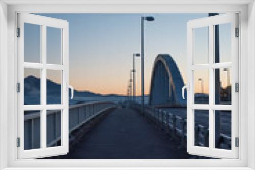 Fototapeta Naklejka Na Ścianę Okno 3D - 太陽が昇る前の橋の上の景色(縦)