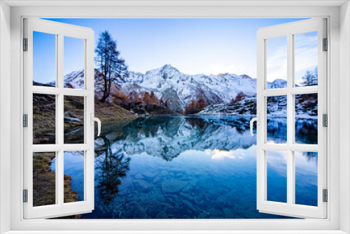 Fototapeta Naklejka Na Ścianę Okno 3D - Reflections of snow capped mountains in a blue icy lake in the mountains