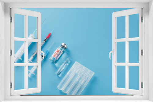 Fototapeta Naklejka Na Ścianę Okno 3D - Ampoule of vaccine medicine with a syringe on a blue background.