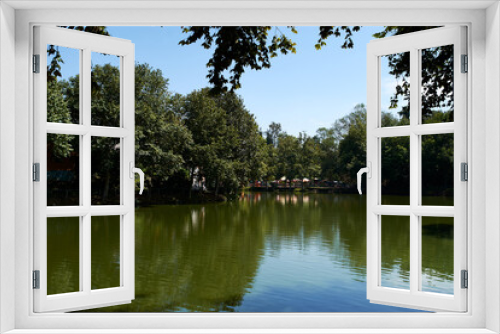 Fototapeta Naklejka Na Ścianę Okno 3D - Lake surrounded by trees and games in the background