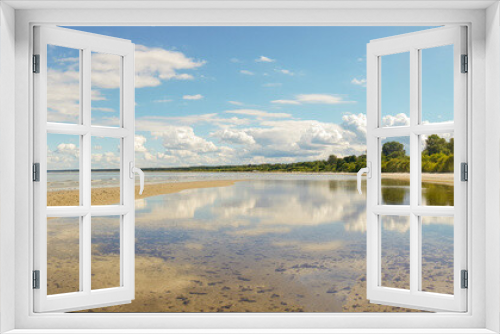 Fototapeta Naklejka Na Ścianę Okno 3D - Calm sea on a sunny summer day. Blue cloudy sky and tree reflection in tranquil water. Holiday and travel concept. Latvian nature. Panoramic view.
