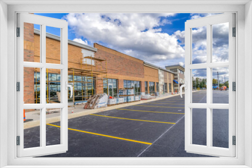 Fototapeta Naklejka Na Ścianę Okno 3D - Refurbished strip mall commercial real estate property under construction in Maryland covered with orange, red brick veneer and scaffolding