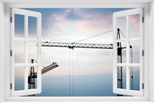 Fototapeta Naklejka Na Ścianę Okno 3D - Construction banner. Cranes in front of sunset sky. Building concept. Copy space