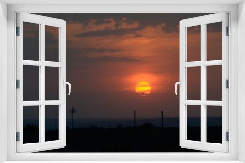 Fototapeta Naklejka Na Ścianę Okno 3D - The antenna is a cellular transmitter and a line of wires against the backdrop of a pink sunset and a blue sky.