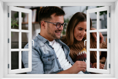 Happy young couple with laptop at home..