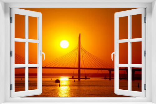 Fototapeta Naklejka Na Ścianę Okno 3D - sunset over the cable-stayed bridge reflecting in the river water