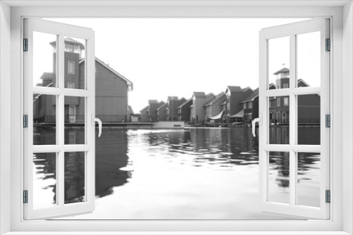 Fototapeta Naklejka Na Ścianę Okno 3D - Black and white picture of Reitdiephaven neighbourhood in Groningen, Netherlands, with floating wood houses among water channels. 