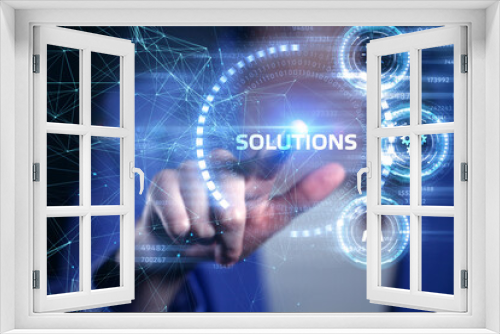 Business, Technology, Internet and network concept. Young businessman working on a virtual screen of the future and sees the inscription: Solutions