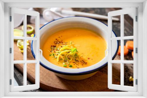 Fototapeta Naklejka Na Ścianę Okno 3D - Tasty carrot creamy soup with herbs and spices in a bowl close-up. Soft focus. Autumn or winter food. Pureed vegetable soup.