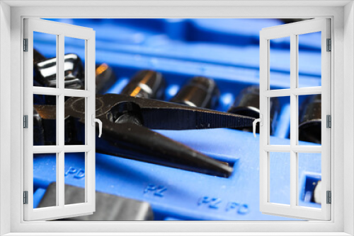 Macro close up of black isolated pliers on blue socket tool set box 